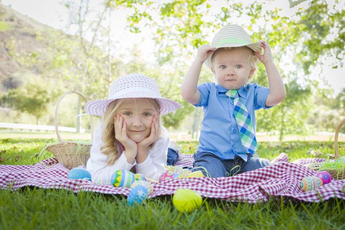 Cute Young Brother and Sister Enjoying Their Easter Eggs Outside