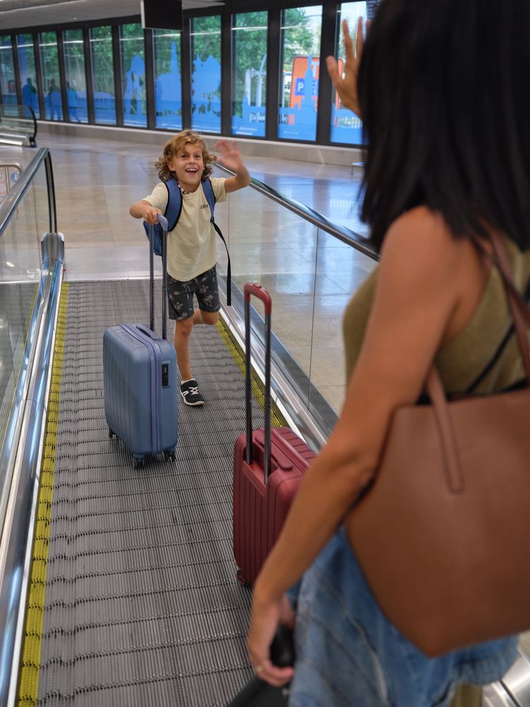 Mother and son waving each other at airport