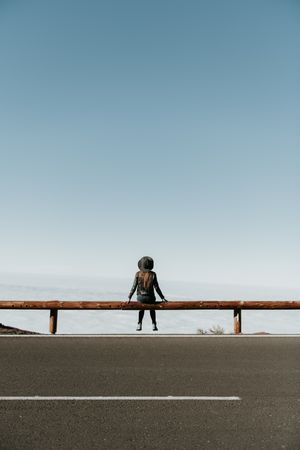 Woman on fence on hill