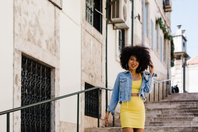 Stylish female standing on stairs with railing outdoors