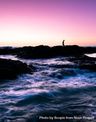 Silhouette of person standing on rock formation on sea water during sunset 5zPkmb