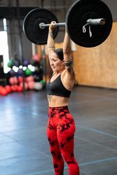 Sporty woman lifting weights alone in a gym