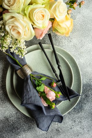 Flowers wrapped with navy napkin on grey plate and concrete table