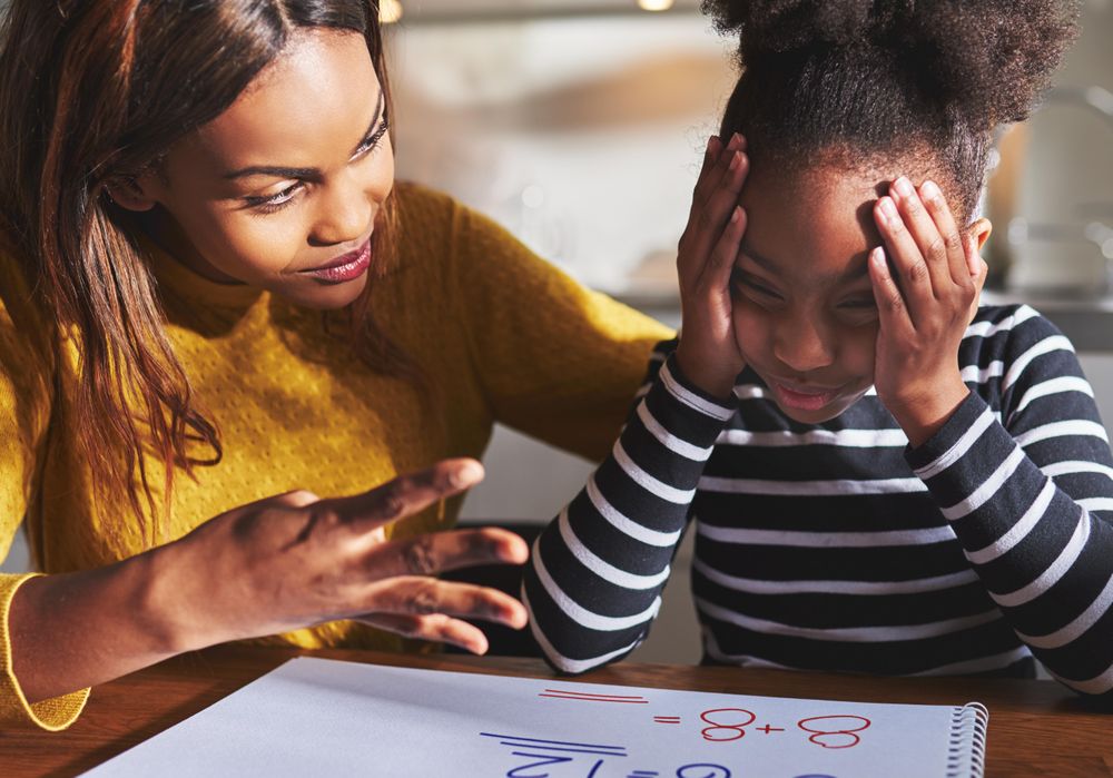 Patient mother helps daughter with frustrating math problem