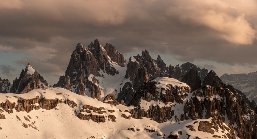 Sharp peaks of rocky mountains against cloudy sky