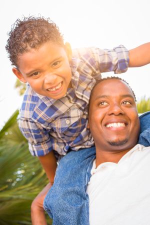 Son and Father Playing Piggyback Outdoors Together.