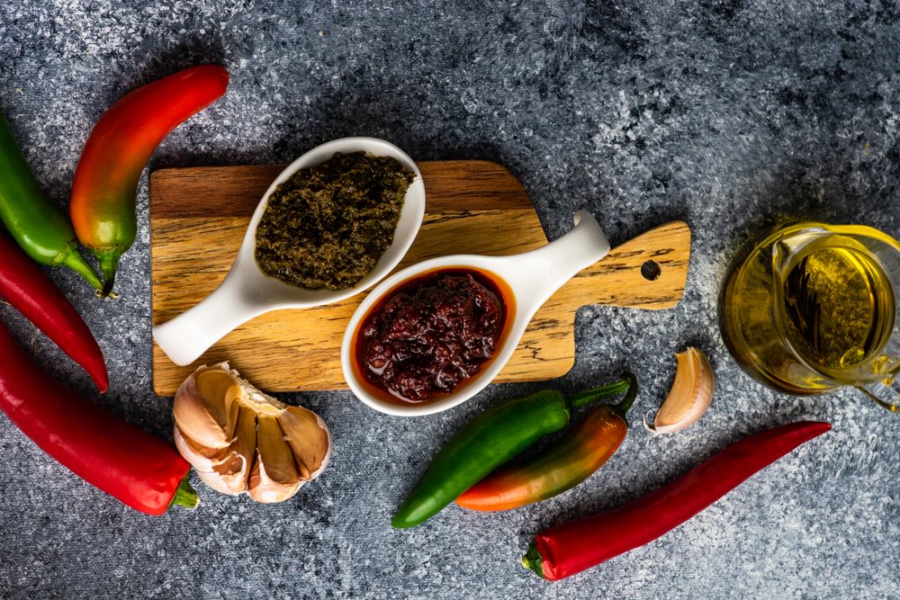 Top view of two servings of Georgian sauce Adjika on wooden board