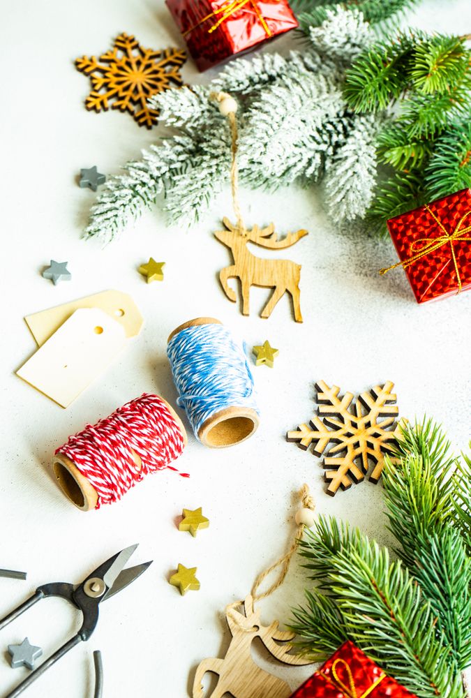 Christmas tree branch with decorative boxes, string and reindeer