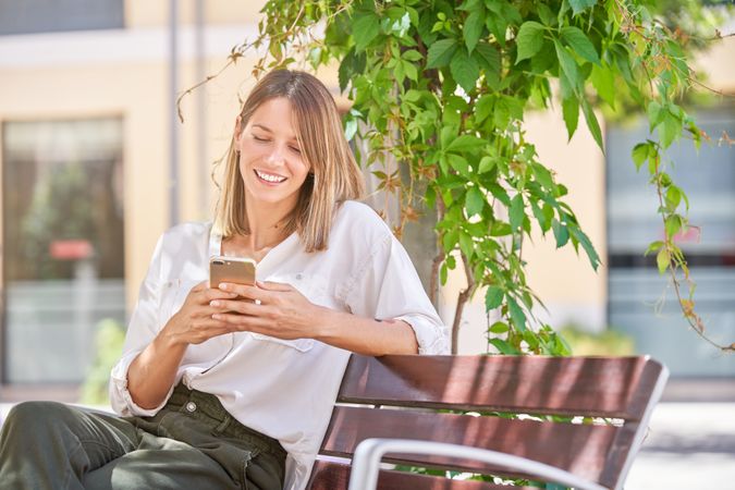 Smiling female with cellphone on street