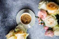 Top view of yellow & pink roses with cup of coffee