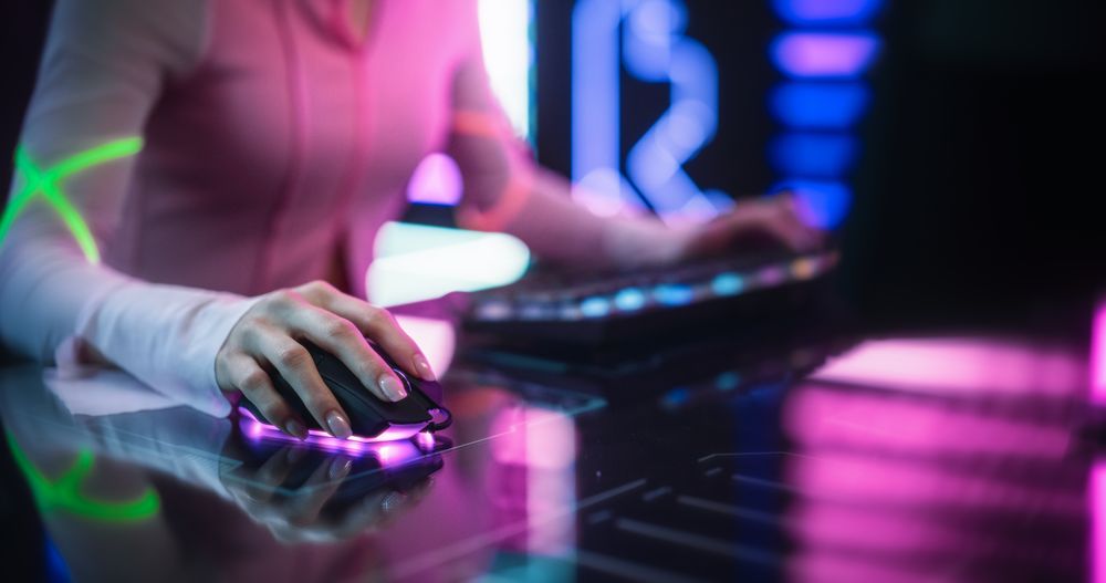 Streamer Sitting Behind a Futuristic Interactive Desk in a Colorful Neon Studio Room