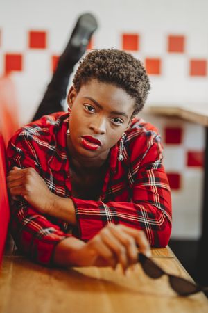 Gorgeous stylish Black woman lying on seats in cafe