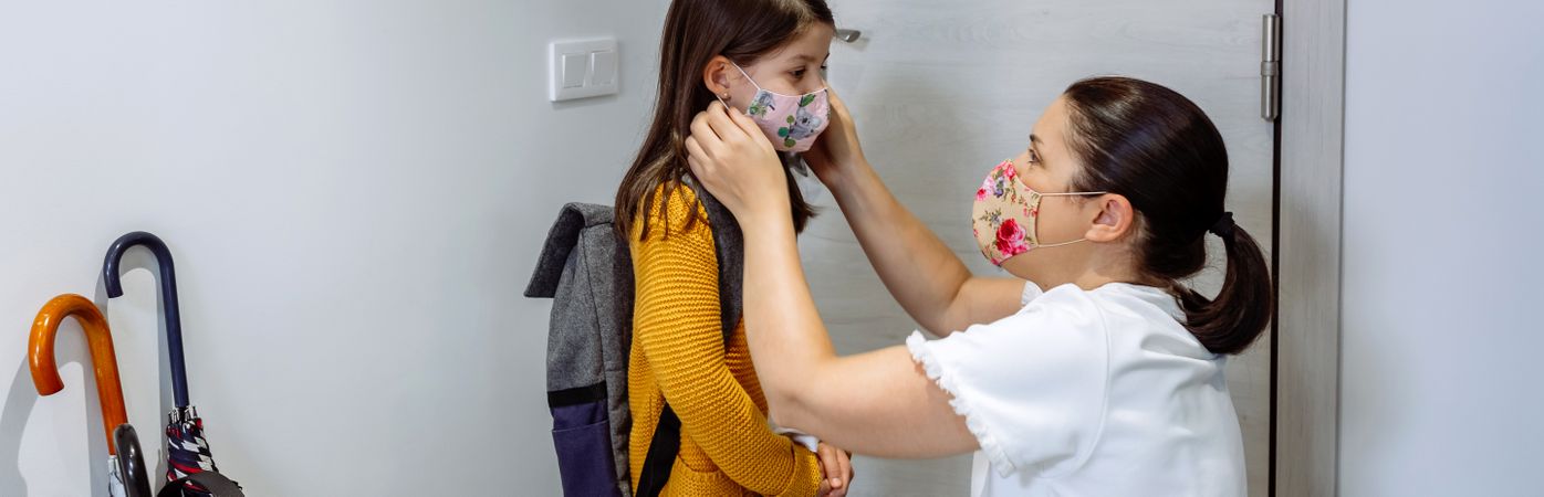 Mother putting the mask on her daughter