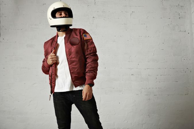 Man in dark red leather jacket and biker helmet in studio shoot