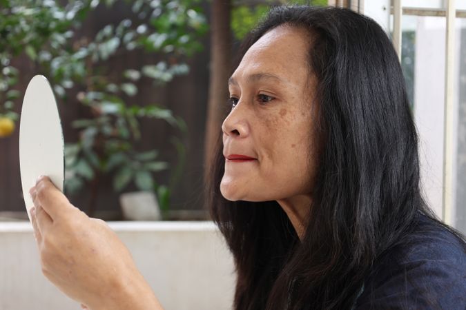 Woman doing make up in the mirror
