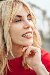 Blonde woman happy with head resting on her hand