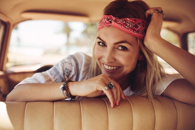 Smiling woman relaxing in the car and looking at camera