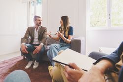 A man and woman discuss their issues during a therapy session