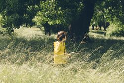 Boy walking on field with trees