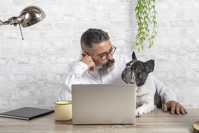 Middle aged man sitting beside dog in the office