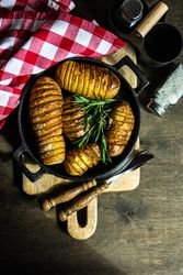 Top view of baked potato fans in iron cast pot on kitchen counter