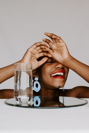 Woman smiling next to glass of water