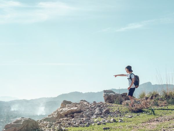Boy with backpack exploring mountains