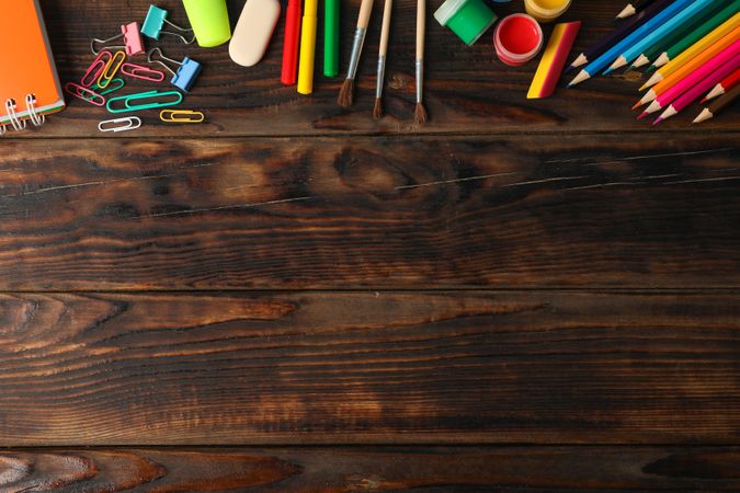 Flat lay composition with school supplies on wooden background, space for text