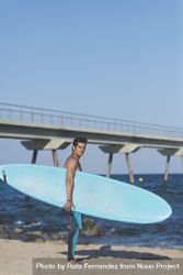 Male surfer with board standing on sunny beach 41ZZ8b