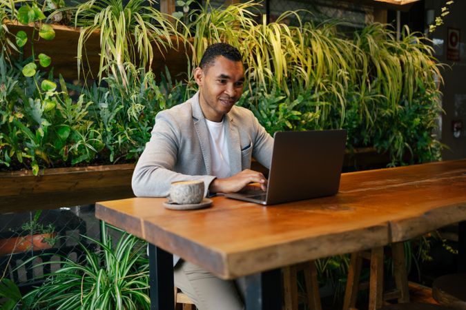 Man working on laptop at cafeteria