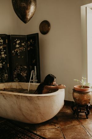 Melancholic Woman sitting and washing in bath