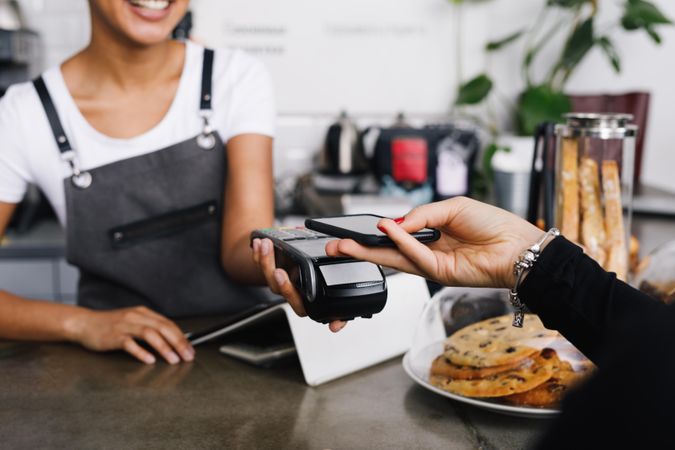 Customer using smart phone to pay at a cafe