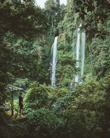 Tourist under hazy waterfall