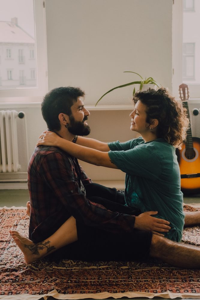 Loving couple embracing while sitting on apartment floor