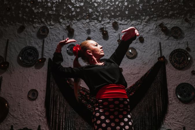 Woman dancer in flamenco costume standing in dance posture