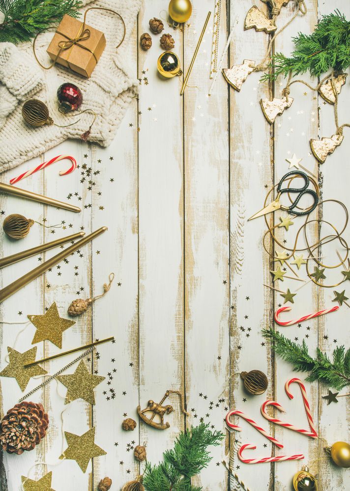 Decorations of stars, candy canes, scissors, candles on light background, vertical composition