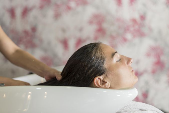 Hair of woman being washed in sink at salon