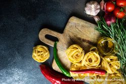 Raw homemade Fettuccine pasta and ingredients on stone rustic background with copy space 5XrwQV