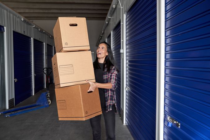 Cheerful woman carrying carton boxes