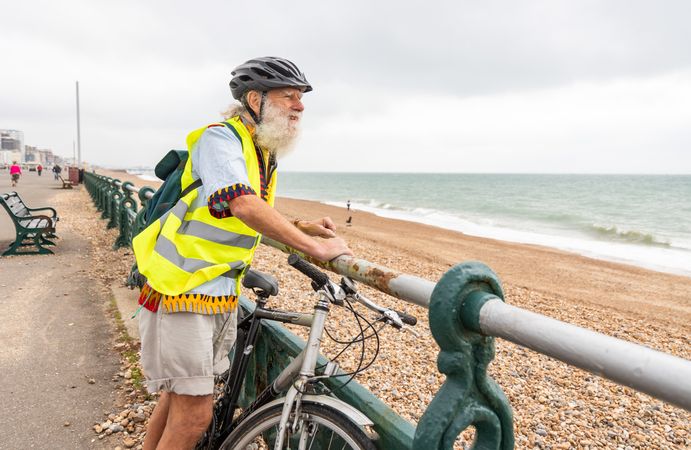 Older man with bike looking at coastal view