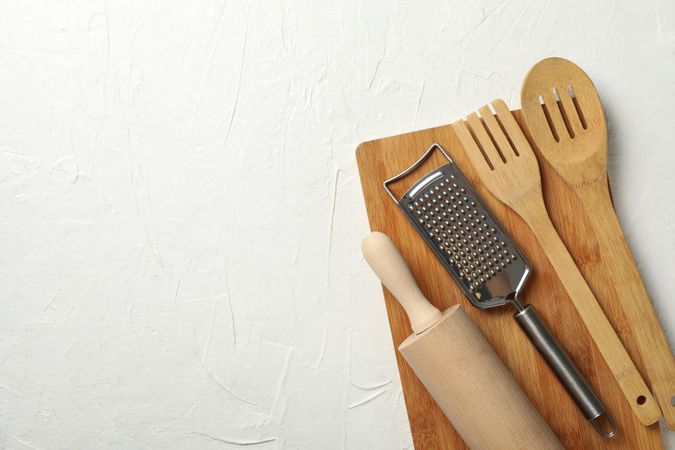 Wooden kitchen cutlery on neutral background, space for text