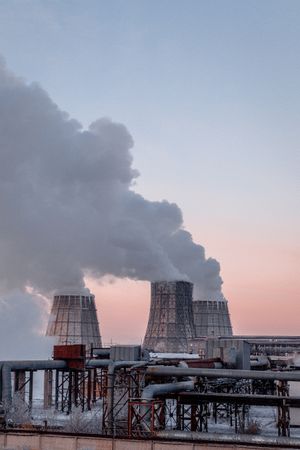 Cooling towers of power plant emitting steam at sunrise