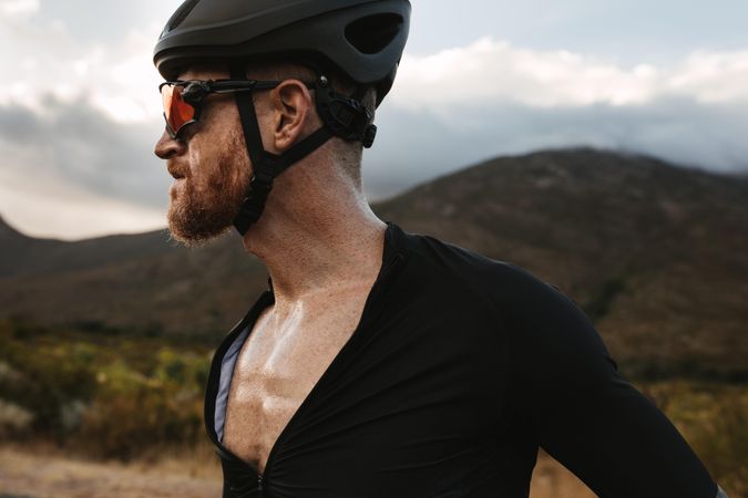 Cyclist wearing a helmet and sunglasses looking away