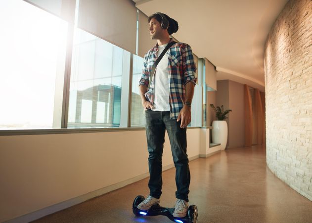 Creative professional on hoverboard in hallway of business