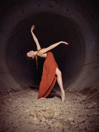 Ballerina in dress dancing in tunnel