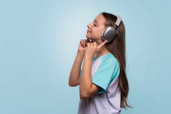 Girl enjoying music with headphones, smiling with her eyes closed