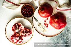 Fresh cut pomegranate on light plate with dishtowel 5X7pK0
