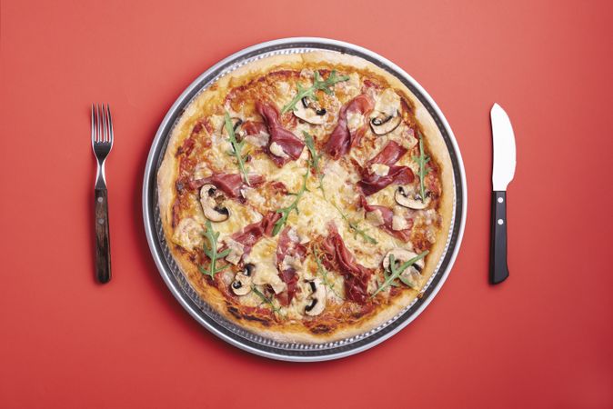 Prosciutto pizza on red background