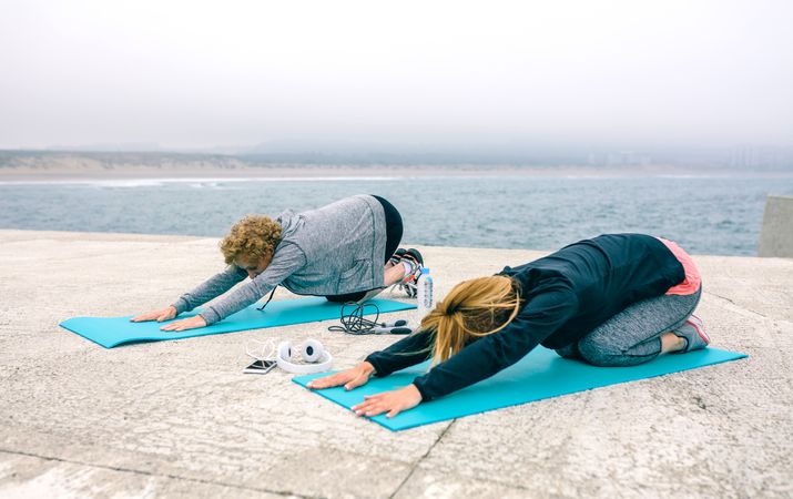 Young and Older woman stretching back outdoors