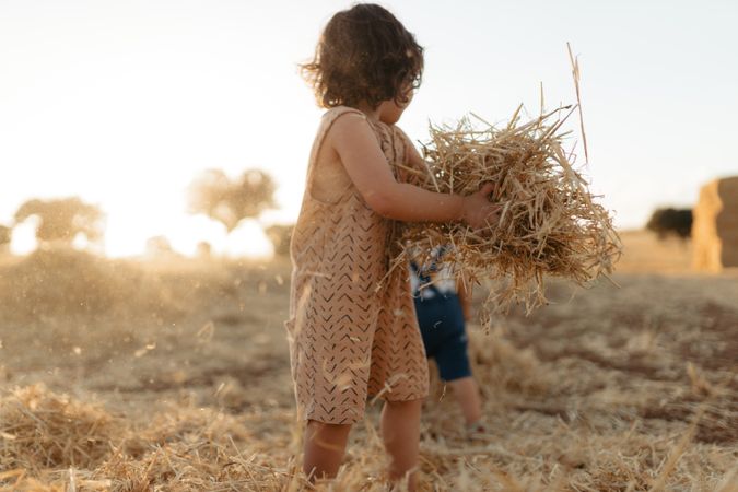 Girl holding a pile of hay